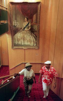 ROYAL VISAGE: Wilhelmina and George Glanville of New York walk up a stairwell on the QE2 with a portrait of Queen Elizabeth behind them. 