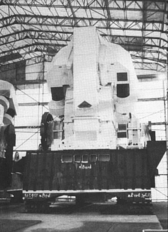 One of the giant GEC propulsion electric motors before installation and being lowered through the funnel hatch.  The funnel can be seen on the quayside off to the left. The ships mast is to the right.