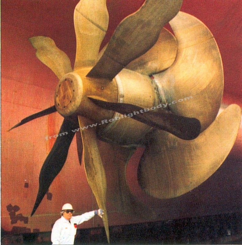 A QE2 propeller with a man underneath to show scale